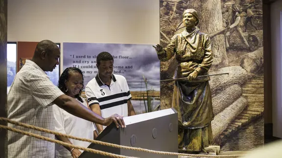 A family reading on a display inside of the Harriet Tubman Underground Railroad visitors Center