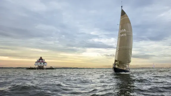 Sailboat racing past Thomas Point Lighthouse